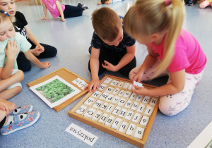 chłopiec z dziewczynką układają napis z literek